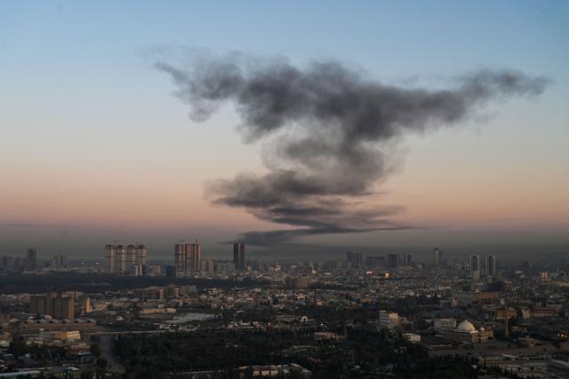 A plume of smoke rises near Erbil International Airport in Erbil on March 1, 2026. Loud explosions were heard early on March 1 near Erbil airport, which hosts US-led coalition troops in Iraq's autonomous Kurdistan region, an AFP journalist said. (Photo by Shvan HARKI / AFP)