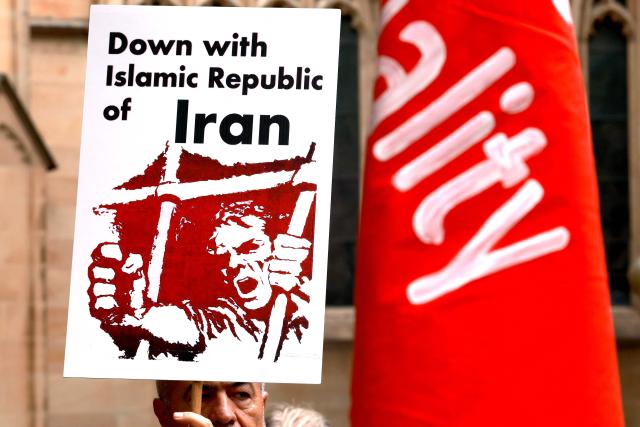 Members of the Iranian community hold placards during a rally in Sydney on March 1, 2026. Australia's Prime Minister Anthony Albanese said on March 1 that Iran's supreme leader Ayatollah Ali Khamenei "will not be mourned", as state media in the Islamic republic confirmed he had been killed. (Photo by DAVID GRAY / AFP)