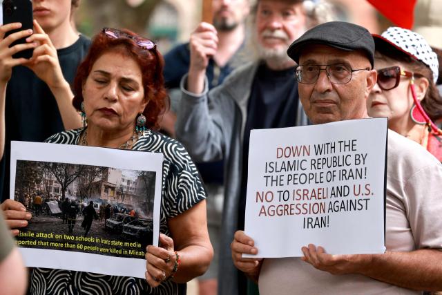 Members of the Iranian community hold placards during a rally in Sydney on March 1, 2026. Australia's Prime Minister Anthony Albanese said on March 1 that Iran's supreme leader Ayatollah Ali Khamenei "will not be mourned", as state media in the Islamic republic confirmed he had been killed. (Photo by DAVID GRAY / AFP)