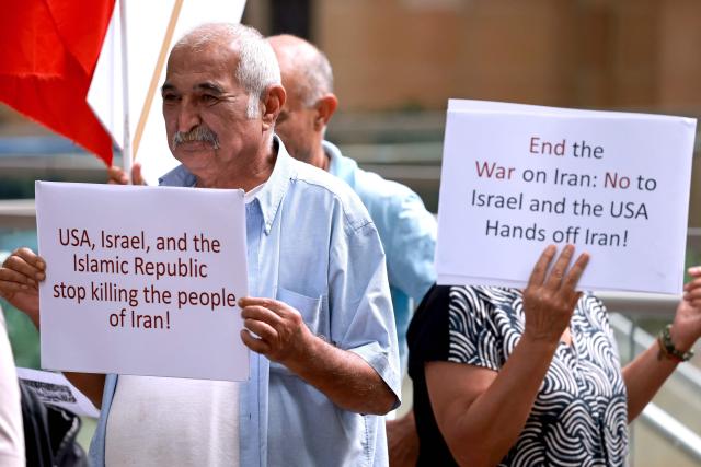 Members of the Iranian community hold placards during a rally in Sydney on March 1, 2026. Australia's Prime Minister Anthony Albanese said on March 1 that Iran's supreme leader Ayatollah Ali Khamenei "will not be mourned", as state media in the Islamic republic confirmed he had been killed. (Photo by DAVID GRAY / AFP)