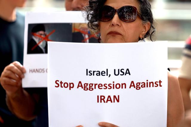 Members of the Iranian community hold placards during a rally in Sydney on March 1, 2026. Australia's Prime Minister Anthony Albanese said on March 1 that Iran's supreme leader Ayatollah Ali Khamenei "will not be mourned", as state media in the Islamic republic confirmed he had been killed. (Photo by DAVID GRAY / AFP)