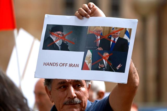 Members of the Iranian community hold placards during a rally in Sydney on March 1, 2026. Australia's Prime Minister Anthony Albanese said on March 1 that Iran's supreme leader Ayatollah Ali Khamenei "will not be mourned", as state media in the Islamic republic confirmed he had been killed. (Photo by DAVID GRAY / AFP)
