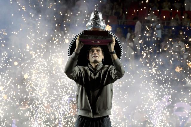 Italy's Flavio Cobolli celebrates with the trophy after defeating US' Frances Tiafoe during the 2026 Mexico ATP 500 Tennis Open men's singles tennis final match at the Arena GNP Seguros in Acapulco, Guerrero State, Mexico on February 28, 2026. (Photo by Alfredo ESTRELLA / AFP)