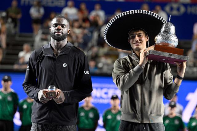 Italy's Flavio Cobolli (R) poses with his trophy after defeating US' Frances Tiafoe (L) during the 2026 Mexico ATP 500 Tennis Open men's singles tennis final match at the Arena GNP Seguros in Acapulco, Guerrero State, Mexico on February 28, 2026. (Photo by Alfredo ESTRELLA / AFP)