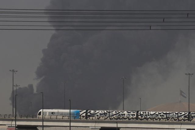 A metro train passes by a plume of smoke rising from the port of Jebel Ali following a reported Iranian strike in Dubai on March 1, 2026. Ayatollah Ali Khamenei, Iran's supreme leader since 1989 and sworn enemy of the West, was killed in the opening salvo of a massive US and Israeli attack, sparking a new wave of retaliatory missile strikes from Tehran on March 1. (Photo by Fadel SENNA / AFP)