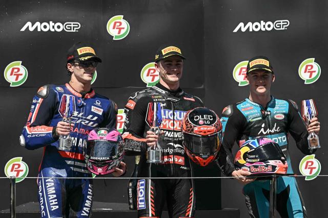 Winner Liqui Moly Dynavolt Intact GP team's Spanish rider Manuel Gonzalez (C), second-placed BLU CRU Pramac Yamaha Moto2 team's Spanish rider Izan Guevara (L) and third-placed CFMOTO Inde Aspar team's Spanish rider Daniel Holgado (R) celebrate on the podium after the Moto2 race at the MotoGP Thailand Grand Prix at the Buriram International Circuit in Buriram on March 1, 2026. (Photo by Lillian SUWANRUMPHA / AFP)