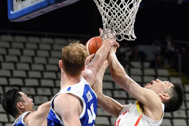 China's Yu Jiahao (R) rebounds against Taiwan's Brandon Gilbeck (C) during the 2027 FIBA Basketball World Cup Asian qualifier first round group B match between China and Taiwan at the Mall of Asia Arena in Pasay city, Metro manila on March 1, 2026. (Photo by Ted ALJIBE / AFP)