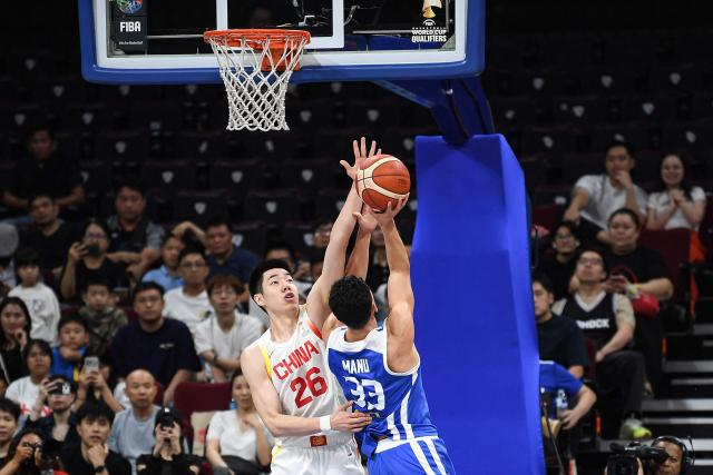 China's Zhu Junlong (L) tries to block an attemp by Taiwan's Samuel Manu during the 2027 FIBA Basketball World Cup Asian qualifier first round group B match between China and Taiwan at the Mall of Asia Arena in Pasay city, Metro manila on March 1, 2026. (Photo by Ted ALJIBE / AFP)