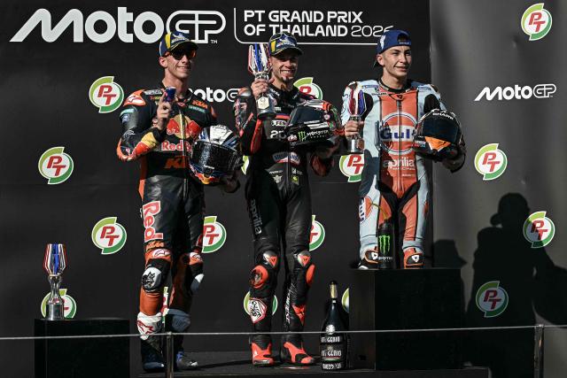Winner Aprilia Racing's Italian rider Marco Bezzecchi (C), second-placed Red Bull KTM Factory Racing's Spanish rider Pedro Acosta (L) and third-placed Trackhouse MotoGP's Spanish rider Raul Fernandez (R) celebrate on the podium after the MotoGP Thailand Grand Prix at the Buriram International Circuit in Buriram on March 1, 2026. (Photo by Lillian SUWANRUMPHA / AFP)