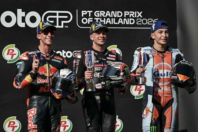 Winner Aprilia Racing's Italian rider Marco Bezzecchi (C), second-placed Red Bull KTM Factory Racing's Spanish rider Pedro Acosta (L) and third-placed Trackhouse MotoGP's Spanish rider Raul Fernandez (R) celebrate on the podium after the MotoGP Thailand Grand Prix at the Buriram International Circuit in Buriram on March 1, 2026. (Photo by Lillian SUWANRUMPHA / AFP)