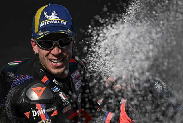 Winner Aprilia Racing's Italian rider Marco Bezzecchi celebrates on the podium after the MotoGP Thailand Grand Prix at the Buriram International Circuit in Buriram on March 1, 2026. (Photo by Lillian SUWANRUMPHA / AFP)