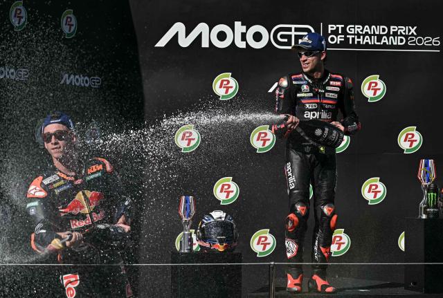 Winner Aprilia Racing's Italian rider Marco Bezzecchi (R) and second-placed Red Bull KTM Factory Racing's Spanish rider Pedro Acosta (L) celebrate on the podium after the MotoGP Thailand Grand Prix at the Buriram International Circuit in Buriram on March 1, 2026. (Photo by Lillian SUWANRUMPHA / AFP)