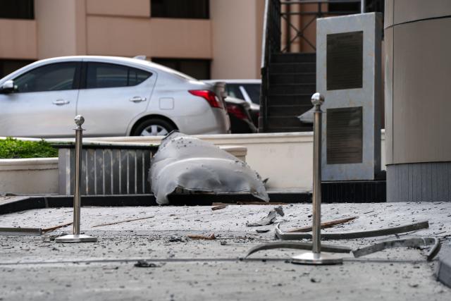 A large piece of shrapnel and debris are scattered on the street outside the damaged Crown Plaza hotel, in Manama on March 1, 2026. Fresh blasts were heard across Dubai, Doha and Manama on March 1, as Iran carried out strikes in retaliation for US and Israeli attacks that killed the supreme leader and other top officials on February 28, 2026. (Photo by Fadhel MADAN / AFP)