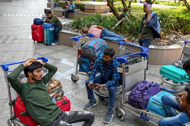 Stranded passengers wait at the departure terminal of Chhatrapati Shivaji Maharaj International Airport in Mumbai on March 1, 2026 after India's two largest private carriers IndiGo and Air India suspended flights to all destinations in the Middle East. Thousands of flights have been delayed or cancelled in the biggest disruption to global air transport since the Covid pandemic as airlines suspend services to the Middle East following the US and Israeli attacks on Iran. (Photo by Punit PARANJPE / AFP)