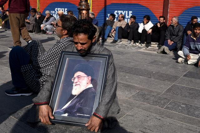 A Shiite Muslim holds a photograph of Iran supreme leader Ali Khamenei during an anti-US and Israel protest in Srinagar on March 1, 2026. Iranian state media confirmed the death of Khamenei, Iran's supreme leader since 1989 and sworn enemy of the West, on March 1, after the opening salvo of a massive US and Israeli attack. In Indian-administered Kashmir, several thousand Shia Muslims joined street demonstrations in the main city Srinagar. (Photo by Habib NAQASH / AFP)
