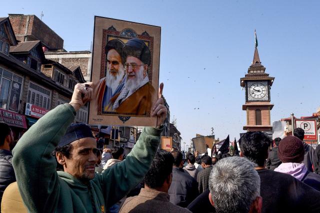 A Shiite Muslim holds a photograph of Iran supreme leader Ayatollah Ali Khamenei (R) and former leader Ayatollah Ruhollah Khomeini during an anti-US and Israel protest in Srinagar on March 1, 2026. Iranian state media confirmed the death of Khamenei, Iran's supreme leader since 1989 and sworn enemy of the West, on March 1, after the opening salvo of a massive US and Israeli attack. In Indian-administered Kashmir, several thousand Shia Muslims joined street demonstrations in the main city Srinagar. (Photo by Habib NAQASH / AFP)
