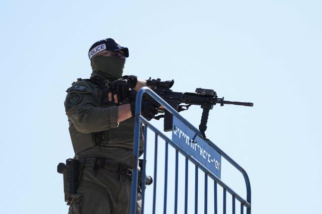 TOPSHOT - A member of Israeli security personnel stands guard in an area that was hit by a reported overnight Iranian strike in Tel Aviv on March 1, 2026. Ayatollah Ali Khamenei, Iran's supreme leader since 1989 and sworn enemy of the West, was killed in the opening salvo of a massive US and Israeli attack, sparking a new wave of retaliatory missile strikes from Tehran on March 1. (Photo by Ilia YEFIMOVICH / AFP)