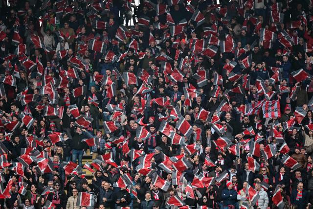 Cremonese supporters wave flags ahead of the Italian Serie A football match between Cremonese and AC Milan at the Giovanni Zini Stadium in Cremona on March 1, 2026. (Photo by Piero CRUCIATTI / AFP)