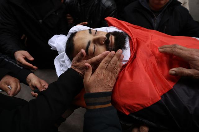 Palestinian relatives mourn over the body of 25-years-old Mohammed Jihad Masalmeh, during his funeral the day after he was shot and killed by the Israeli military during a raid, in the village of Dura, in the Israeli-occupied West Bank on March 1, 2026. (Photo by HAZEM BADER / AFP)