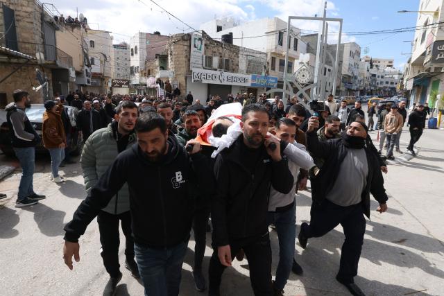Palestinians carry the body of 25-years-old Mohammed Jihad Masalmeh, during the day after he was shot and killed by the Israeli military during a raid, in the village of Dura, in the Israeli-occupied West Bank on March 1, 2026. (Photo by HAZEM BADER / AFP)
