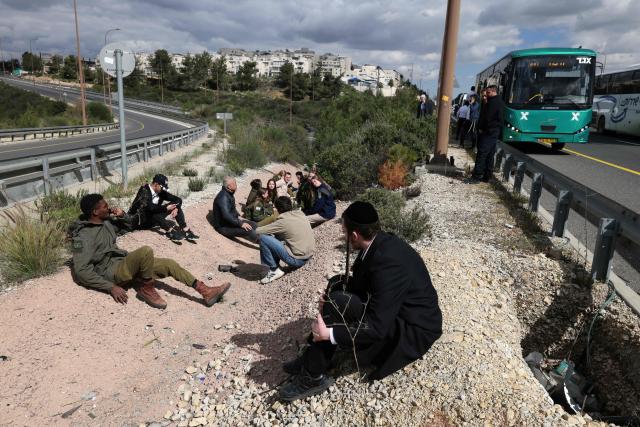 Israelis leave their vehicles and take cover as air raid siren sound, in Abu Ghosh near Jerusalem on March 1, 2026. Iran's clerical leaders vowed to avenge the death of its supreme leader and launched a fresh wave of attacks on March 1, as Israel hit back at the capital Tehran. (Photo by AHMAD GHARABLI / AFP)