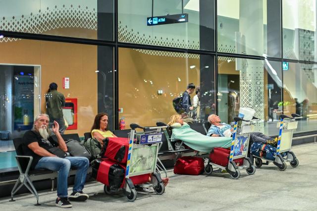 Stranded passengers wait at the Velana International Airport in Male on March 1, 2026 after the cancellation of several flights destined for the Middle East. The biggest disruption to global air transport since the Covid pandemic continued on March 1, with thousands of flights affected and busy Middle Eastern hubs including Dubai and Doha shuttered as Iran lashed out after US-Israeli strikes. (Photo by Mohamed Afrah / AFP)