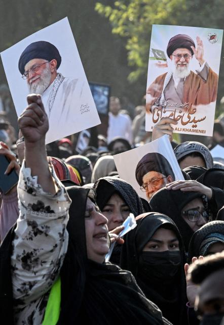 Shiite Muslims hold portraits of Iran's late supreme leader Ayatollah Ali Khamenei as they attempt to storm the US embassy in Islamabad on March 1, 2026 after the death of Iran's supreme leader Khamenei amid US-Israel strikes. At least nine people were killed during pro-Iran protests at the United States consulate in the Pakistan megacity of Karachi on March 1, according to a hospital toll seen by AFP. (Photo by Aamir QURESHI / AFP)