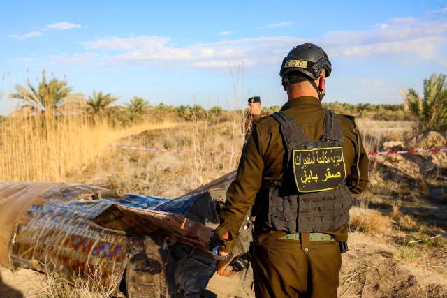 Members and officers from the Iraqi Interior Ministry's Explosives Directorate inspect the fuel tank of a rocket that landed in a rural village in the Siyahi area near the city of Hilla in the central Babil province on March 1, 2026. Iraq, which has recently regained a sense of stability but has long been a proxy battleground between the US and Iran, warned that it did not want to be dragged into the war that started on February 28 with US and Israeli strikes on Iran. (Photo by Karrar Jabbar / AFP)