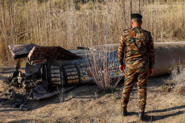 Members and officers from the Iraqi Interior Ministry's Explosives Directorate inspect the fuel tank of a rocket that landed in a rural village in the Siyahi area near the city of Hilla in the central Babil province on March 1, 2026. Iraq, which has recently regained a sense of stability but has long been a proxy battleground between the US and Iran, warned that it did not want to be dragged into the war that started on February 28 with US and Israeli strikes on Iran. (Photo by Karrar Jabbar / AFP)