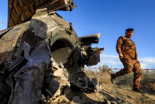 Members and officers from the Iraqi Interior Ministry's Explosives Directorate inspect the fuel tank of a rocket that landed in a rural village in the Siyahi area near the city of Hilla in the central Babil province on March 1, 2026. Iraq, which has recently regained a sense of stability but has long been a proxy battleground between the US and Iran, warned that it did not want to be dragged into the war that started on February 28 with US and Israeli strikes on Iran. (Photo by Karrar Jabbar / AFP)