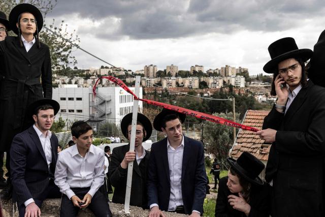 Ultra-Orthodox men look on at the scene of a missile attack near Bet Shemesh, some 30 kilometres west of Jerusalem on March 1, 2026. A barrage of missiles launched from Iran killed at least six people in the central Israel city of Bet Shemesh on March 1, Israel's first responders agency, Magen David Adom (MDA) said, the day after the US and Israel attacked Iran and assassinated its supreme leader. (Photo by JOHN WESSELS / AFP)