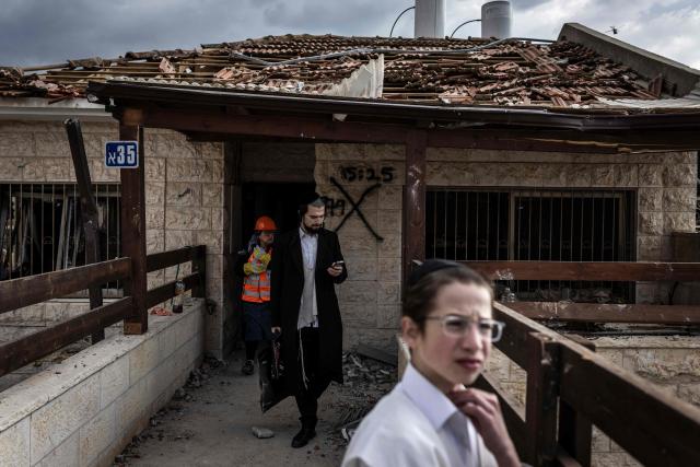 Two men stand in front of a destroyed house at the scene of a missile attack at Bet Shemesh, some 30 kilometres west of Jerusalem on March 1, 2026. A barrage of missiles launched from Iran killed at least six people in the central Israel city of Bet Shemesh on March 1, Israel's first responders agency, Magen David Adom (MDA) said, the day after the US and Israel attacked Iran and assassinated its supreme leader. (Photo by JOHN WESSELS / AFP)