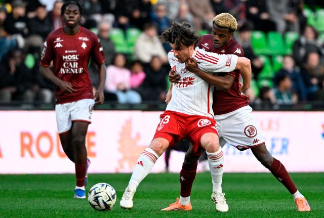 Brest's French midfielder #13 Joris Chotard (C) fights for the ball with Metz' Senegalese midfielder #12 Alpha Toure (R) during the French L1 football match between FC Metz and Stade Brestois 29 (Brest) at the Saint-Symphorien stadium in Longeville-les-Metz, eastern France on March 1, 2026. (Photo by Jean-Christophe VERHAEGEN / AFP)