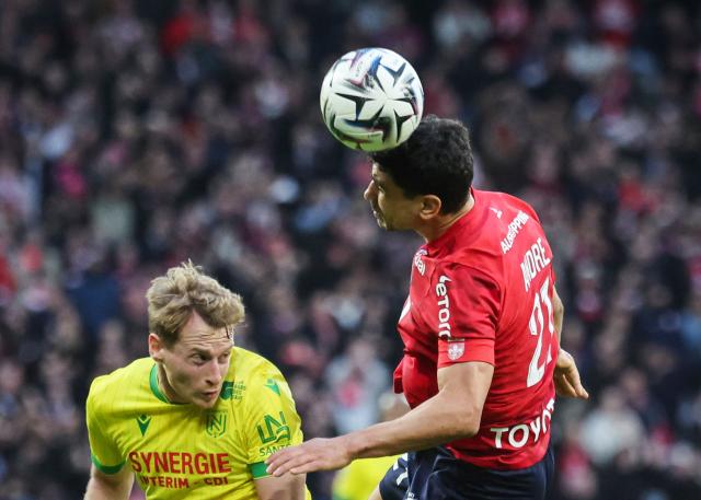 Lille's French midfielder #21 Benjamin Andre(R) heads the ball as he fights for it with Nantes' French defender #03 Nicolas Cozzafight during the French L1 football match between Lille LOSC and FC Nantes at the Stade Pierre-Mauroy in Villeneuve-d'Ascq, northern France, on March 1, 2026. (Photo by Francois LO PRESTI / AFP)