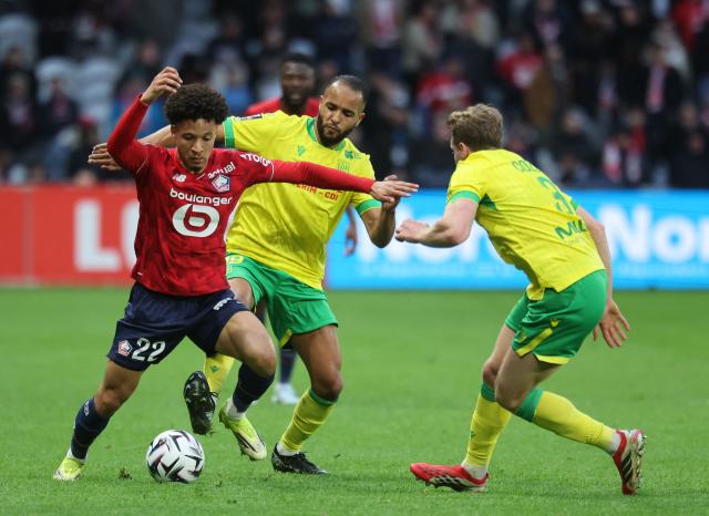 Lille's Portuguese defender #22 Tiago Santos (L) fights for the ball with Nantes' French defender #03 Nicolas Cozza during the French L1 football match between Lille LOSC and FC Nantes at the Stade Pierre-Mauroy in Villeneuve-d'Ascq, northern France, on March 1, 2026. (Photo by Francois LO PRESTI / AFP)