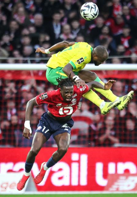 Lille's Congolese midfielder #17 Ngal'Ayel Mukau (down) fights for the ball with Nantes' Cameroonian forward #37 Ignatius Ganago (up) during the French L1 football match between Lille LOSC and FC Nantes at the Stade Pierre-Mauroy in Villeneuve-d'Ascq, northern France, on March 1, 2026. (Photo by Francois LO PRESTI / AFP)