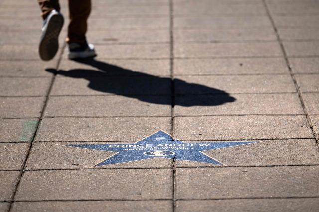 A person walks past a star with the name of former British prince Andrew Mountbatten-Windsor along the "Jeffrey Epstein Walk of Shame," which features prominent names that appear in the Epstein files, near the White House on March 1, 2026, in Washington, DC. (Photo by Brendan Smialowski / AFP)