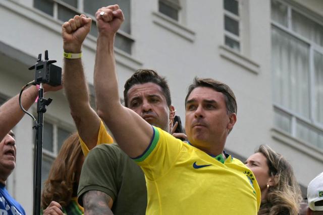 Senator and presidential candidate Flavio Bolsonaro (R) gestures to supporters of Brazil's former president Jair Bolsonaro (2019-2022), sentenced to 23 years and 3 months for attempted coup, during a demonstration in Sao Paulo, Brazil, on March 1, 2026. (Photo by NELSON ALMEIDA / AFP)