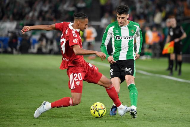Sevilla's Swiss midfielder #20 Djibril Sow and Real Betis' Spanish midfielder #21 Marc Roca fight for the ball during the Spanish league football match between Real Betis and Sevilla FC at Benito Villamarin Stadium in Seville on March 1, 2026. (Photo by CRISTINA QUICLER / AFP)