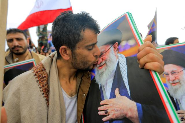 TOPSHOT - A man kisses a picture of Iran's supreme leader Ali Khamenei during a memorial rally held by supporters of Yemen's Huthis, a day after Khamenei was assassinated during US and Israeli strikes on Tehran, in the Huthi-held capital Sanaa on March 1, 2026. The United States and Israel launched strikes against Iran on February 28, killing Iran's supreme leader and top military leaders, prompting authorities to retaliate with strikes on Israel and US bases across the Gulf. (Photo by Mohammed HUWAIS / AFP)