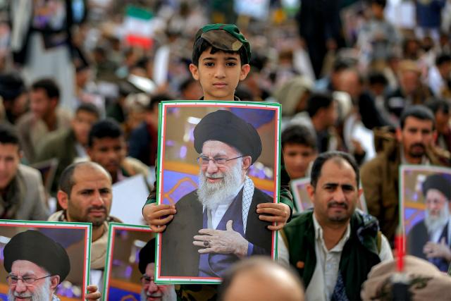 TOPSHOT - A boy holds a picture of Iran's supreme leader Ali Khamenei during a memorial rally held by supporters of Yemen's Huthis, a day after Khamenei was assassinated during US and Israeli strikes on Tehran, in the Huthi-held capital Sanaa on March 1, 2026. The United States and Israel launched strikes against Iran on February 28, killing Iran's supreme leader and top military leaders, prompting authorities to retaliate with strikes on Israel and US bases across the Gulf. (Photo by Mohammed HUWAIS / AFP)
