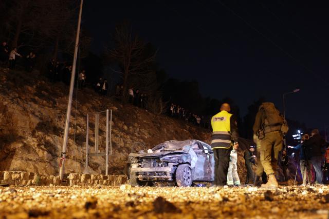 Israel security forces inspect a damaged car after a missile struck a road in Jerusalem on March 1, 2026. The United States and Israel launched strikes against Iran on February 28, killing Iran's supreme leader and top military leaders, prompting authorities to retaliate with strikes on Israel and US bases across the Gulf. (Photo by HAZEM BADER / AFP)