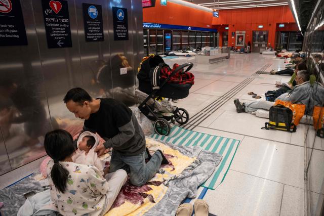 A family with a two-month-old child takes shelter in a train station during an ongoing rocket attack from Iran in Tel Aviv, Israel on March 1, 2026. The United States and Israel launched strikes against Iran on February 28, killing Iran's supreme leader and top military leaders, prompting authorities to retaliate with strikes on Israel and US bases across the Gulf. (Photo by Maya Levin / AFP)