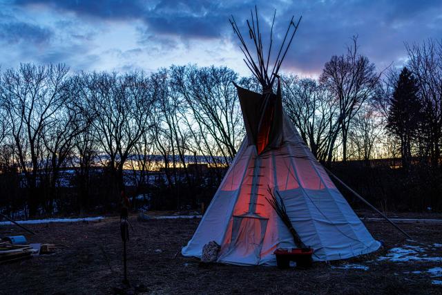 A teepee tent is seen at the Indigenous-led prayer camp across from the Bishop Henry Whipple Federal Building in Minneapolis, Minnesota, on March 1, 2026. The prayer camp was established at the sacred site of Mni Owe Sni (Coldwater Spring), where Indigenous organizers have been gathering in recent weeks to pray for families affected by immigration enforcement and to call for "ICE out" and "Land Back." Indigenous leaders say immigration enforcement and detention echo historic patterns of displacement and incarceration experienced by Native communities. (Photo by Kerem YUCEL / AFP)