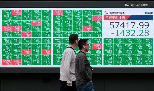 An electronic quotation board displays numbers of the Nikkei Stock Average on the Tokyo Stock Exchange along a street in Tokyo on March 2, 2026. Asian stocks dropped in early trade March 2 on the back of fears for the global economy following US-Israeli attacks on Iran over the weekend. (Photo by Kazuhiro NOGI / AFP)