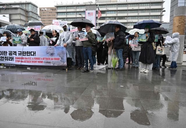 Protesters hold placards reading "Stop the attack right now!" during a demonstration to condemn the US and Israeli attacks on Iran in front of the US embassy in Seoul on March 2, 2026. (Photo by Jung Yeon-je / AFP)