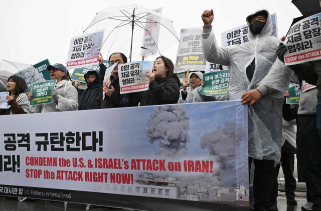 Protesters hold placards reading "Stop the attack right now!" during a demonstration to condemn the US and Israeli attacks on Iran in front of the US embassy in Seoul on March 2, 2026. (Photo by Jung Yeon-je / AFP)