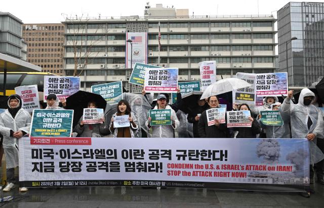 Protesters hold placards reading "Stop the attack right now!" during a demonstration to condemn the US and Israeli attacks on Iran in front of the US embassy in Seoul on March 2, 2026. (Photo by Jung Yeon-je / AFP)