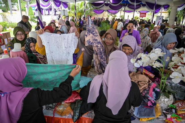 People receive free items such as clothing, staple foods and household items provided by the Women's Organization Association (GOW) and the local government during an annual social action event during Ramadan in Surabaya on March 2, 2026. (Photo by JUNI KRISWANTO / AFP)