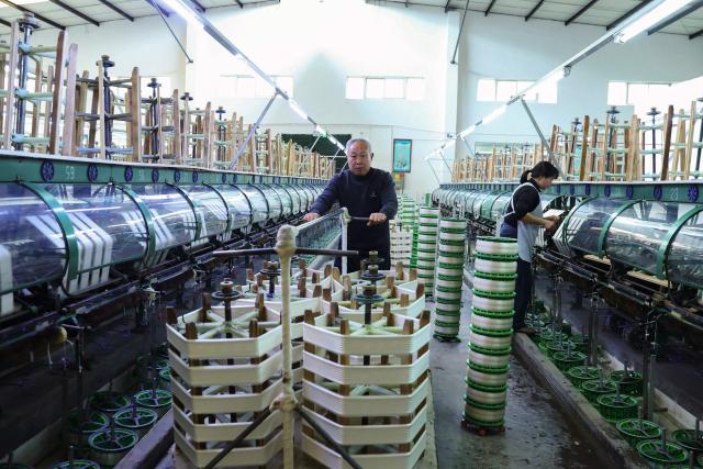 Employees work at a silk factory in Chongqing's Qianjiang district, southwestern China on March 1, 2026. (Photo by CN-STR / AFP) / China OUT